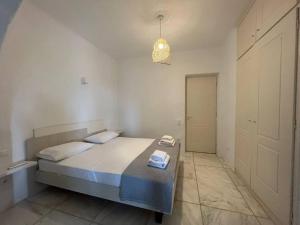 1 dormitorio con 1 cama y luz colgante en Villa Cybele Tinos, en Kardhianí