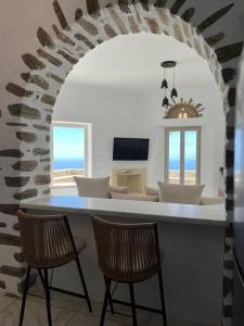 Sala de estar con 2 sillas y mesa con vistas al océano en Villa Cybele Tinos, en Kardhianí