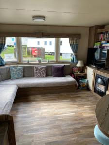 a living room with a couch and a tv at Setons Getaway in Port Seton