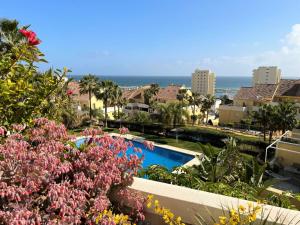 uma vista para um resort com uma piscina e flores em Puerto Alto 6-3 with stunning sea-view em Estepona