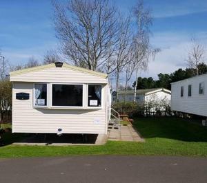 a white tiny house is parked in a yard at Setons Getaway in Port Seton