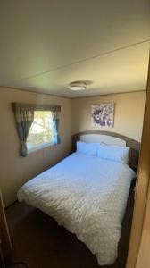 a bedroom with a white bed with a window at Setons Getaway in Port Seton