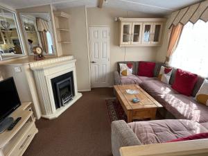 a living room with a couch and a fireplace at Eagle 63, Scratby - California Cliffs, Parkdean, sleeps 6, pet friendly, bed linen and towels included - close to the beach in Scratby