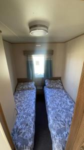 a small room with two beds and a window at Setons Getaway in Port Seton