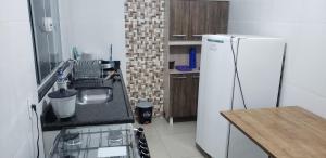 a kitchen with a white refrigerator and a counter top at Apartamento Aparecida do norte in Aparecida