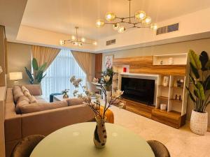 a living room with a couch and a table at Ocean Terrace Apartment in Abu Dhabi