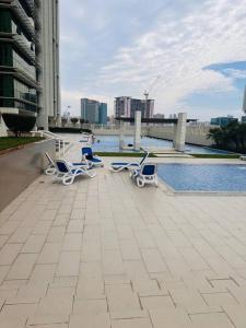 a group of chairs sitting on a patio near the water at Ocean Terrace Apartment in Abu Dhabi