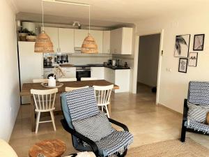 uma cozinha e sala de estar com mesa e cadeiras em Puerto Alto 6-3 with stunning sea-view em Estepona