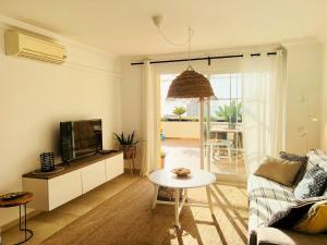 ein Wohnzimmer mit einem Sofa, einem TV und einem Tisch in der Unterkunft Puerto Alto 6-3 with stunning sea-view in Estepona