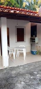 um pátio com uma mesa e cadeiras numa casa em Cantinho do Relax em Vera Cruz de Itaparica