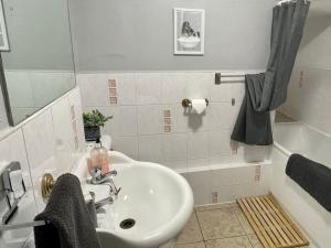 a bathroom with a sink and a bath tub at Navaar House Hotel in Penicuik