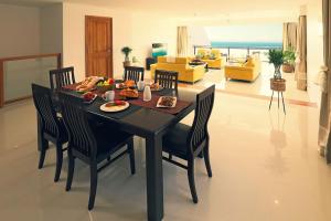 a dining room with a table with food on it at Private Large VIP bedroom with en-suite in shared Deluxe Pool villa by Cliffhanger in Mahe