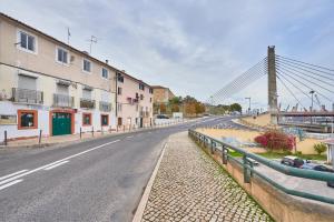 an empty street with a bridge in the background at Cozy Flat in Santa Apolonia in Lisbon