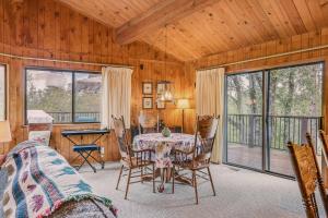 a dining room with a table and chairs and windows at Serene Groveland Cabin Rental Near Yosemite! in Groveland