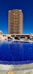 ein großes Hotel mit einem großen Pool vor einem Gebäude in der Unterkunft Praia da Rocha Summer Beach Sea View in Portimão