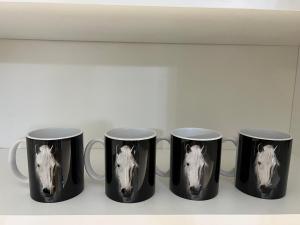 un grupo de cuatro tazas de café con una cabeza de caballo. en Black Horse 24h zameldowanie, en Gdynia