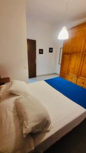 Apartamentos azayara في فرونتيرا: غرفة نوم مع سرير أبيض كبير مع أرضية زرقاء