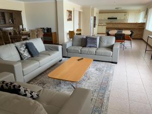 a living room with two couches and a table at Ocean Vista Beach Stay in Rockingham
