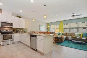 uma cozinha com armários brancos e uma sala de estar em Four Bedrooms Townhouse 5102 em Kissimmee