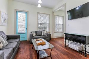 a living room with a couch and a flat screen tv at La Belle Luxe 3qnbed, walk to street car! in New Orleans