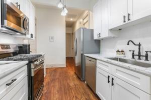 a kitchen with white cabinets and a stainless steel refrigerator at La Belle Luxe 3qnbed, walk to street car! in New Orleans