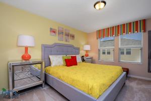 1 dormitorio con 1 cama con colcha amarilla y ventana en Four Bedrooms Townhome 5126K, en Kissimmee
