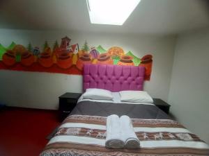 1 dormitorio con 1 cama con cabecero morado en America Guest House, en Cusco