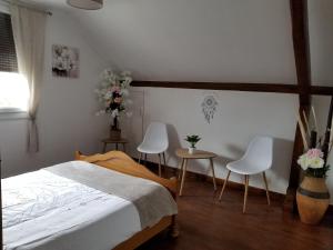 1 Schlafzimmer mit einem Bett sowie 2 Tischen und Stühlen in der Unterkunft Le Jardin des Lumières à La Primaube in Flavin