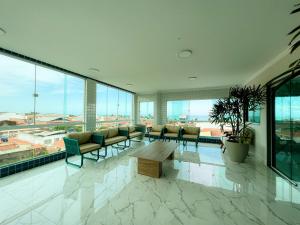 a large room with chairs and a table and windows at Pousada Marítimos in Maragogi