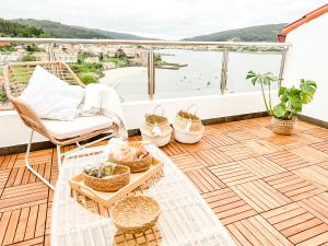 a balcony with a rattan chair and a table at El Olivo by ALÔGA in Corcubión