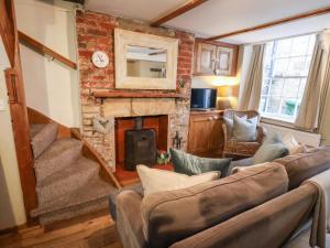 a living room with a couch and a fireplace at Delft Cottage in Robin Hood's Bay