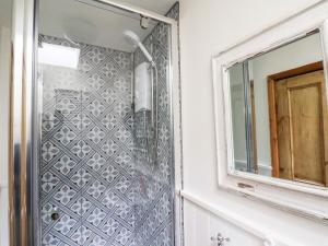 a shower in a bathroom with a mirror at Delft Cottage in Robin Hood's Bay +30 photos
