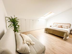 a white room with a bed and a couch at El Olivo by ALÔGA in Corcubión