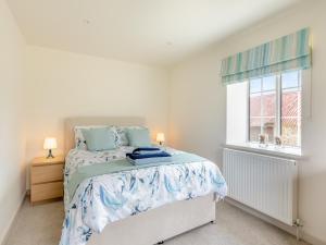 a bedroom with a bed and a window at The Cottage Middle West Water in Axminster