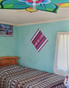- une chambre avec un lit et un ventilateur de plafond dans l'établissement Dawn House, à Ocosuyo