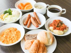 a table with plates of breakfast foods and a cup of coffee at Comfort Hotel Central International Airport in Tokoname