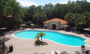- une piscine avec un palmier en face d'une maison dans l'établissement Four Bedrooms Townhome 5108K, à Kissimmee