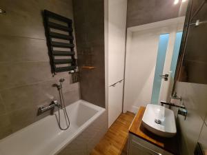a bathroom with a bath tub and a sink at JR Smolna in Poznań