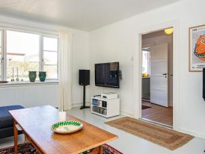a living room with a table and a tv at Charming Village Retreat - By Traum Ferienwohnungen in Ulfborg