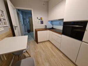 una cocina con armarios blancos y un aparato negro en JR Smolna en Poznan