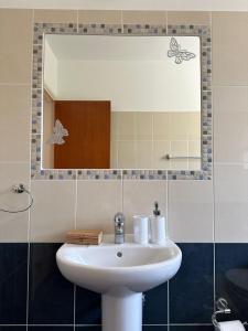 uma casa de banho com um lavatório e um espelho em Berenike Holiday Apartment em Kissonerga