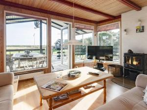 a living room with a table and a fireplace at Two-Bedroom Holiday home in Hurup Thy 2 in Sindrup