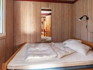 a bed in a room with wood paneling at Two-Bedroom Holiday home in Hurup Thy 2 in Sindrup