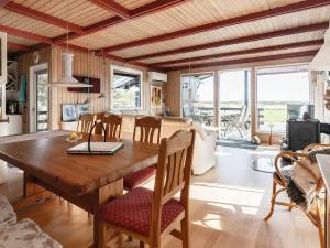 a dining room and living room with a wooden table at Two-Bedroom Holiday home in Hurup Thy 2 in Sindrup