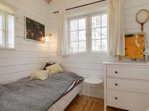 a bedroom with a bed and a dresser and windows at Holiday home Løgstør IX in Løgstør