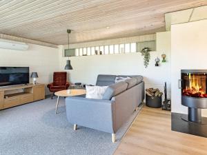 ein Wohnzimmer mit einem Sofa und einem Kamin in der Unterkunft Holiday home Vesløs IV in Øsløs