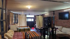 a living room with a couch and a tv on a brick wall at Loft casa dos pisos con garage pocitos playa 4 personas in Montevideo