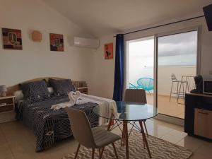 1 dormitorio con cama y mesa de cristal con vistas en Cibuqueira numéro 8 , centre ville, vue sur mer, plage à pied, en Le Moule