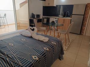 un dormitorio con una cama con un animal de peluche en Cibuqueira numéro 8 , centre ville, vue sur mer, plage à pied, en Le Moule