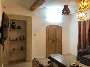a living room with a wooden door and a couch at Dar Chahla in Tozeur